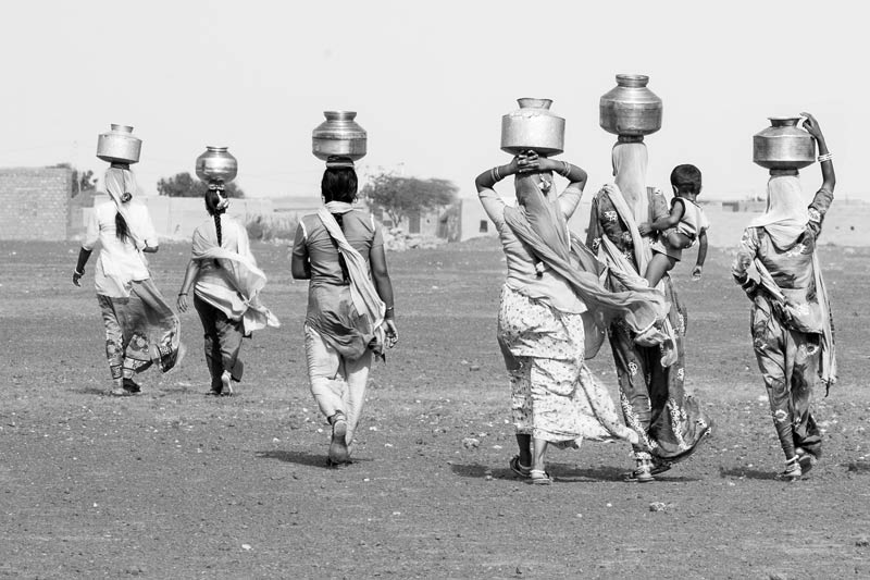 Rural Drinking Water Challenges - Women carrying drinking water in the scorching sun from a distant source in Thar Desert, Jaisalmer district, Rajasthan